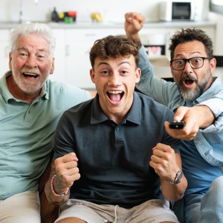 Grandfather, father and son celebrating watching tv