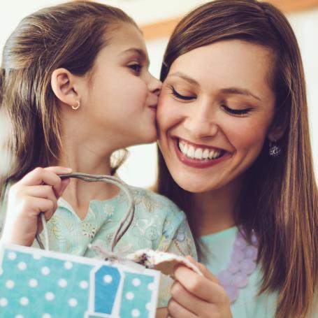 Daughter kissing mum on the cheek