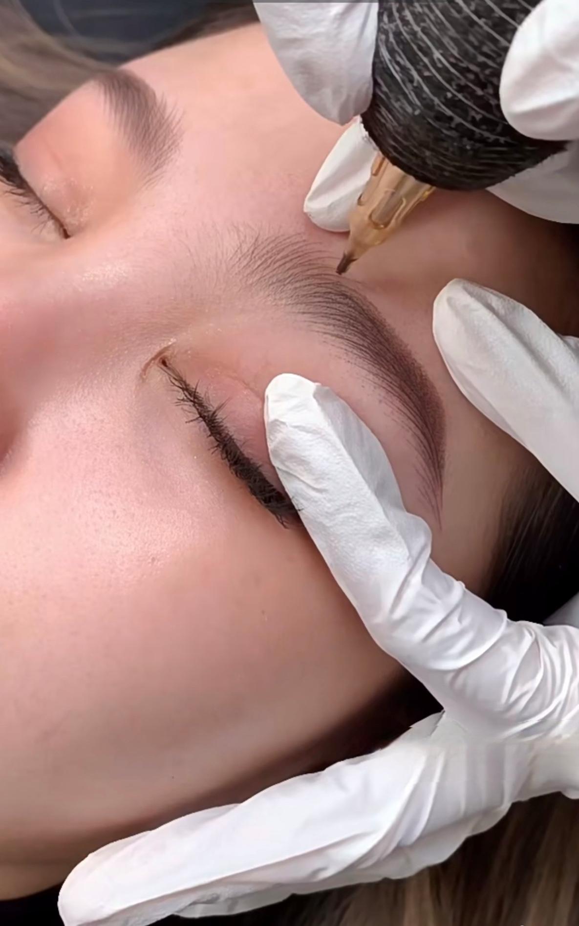 Female getting her eyebrows tattooed