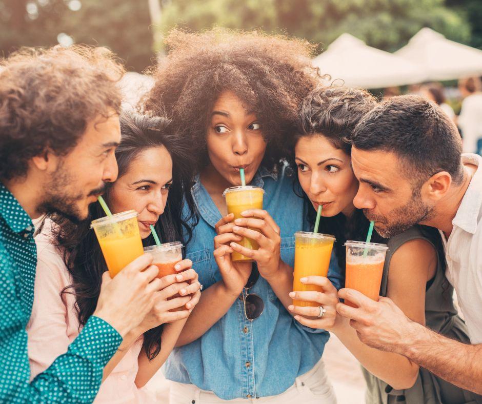 Group of young adults sipping juice