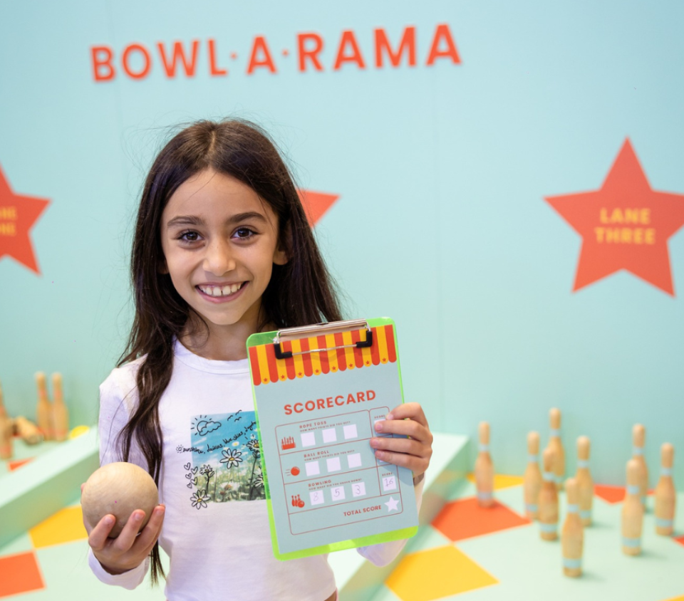 Girl holding a scorecard and ball