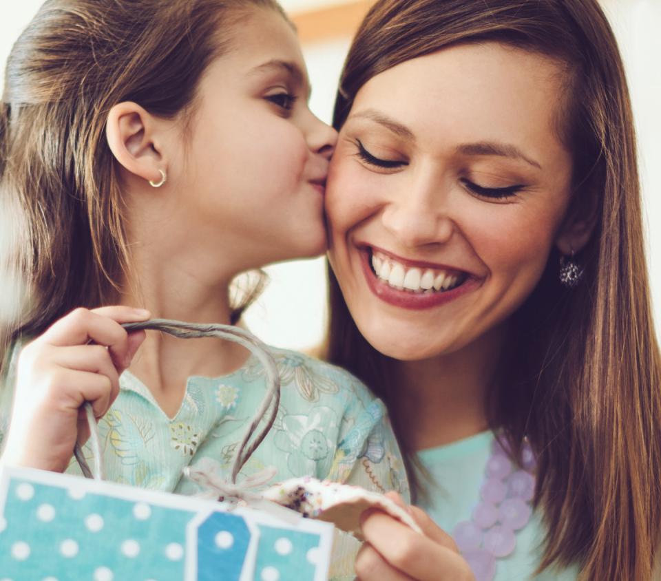 Daughter kissing mum on the cheek