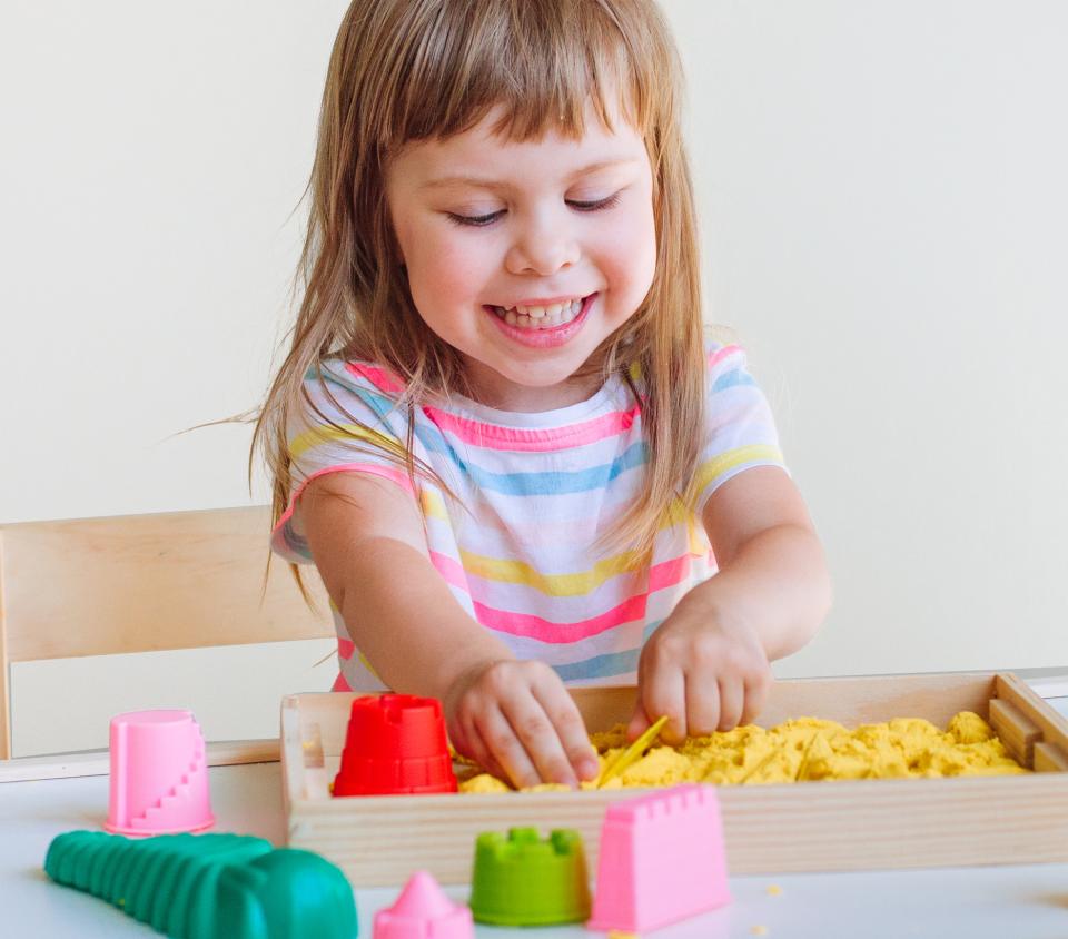 Little girl playing in play doh